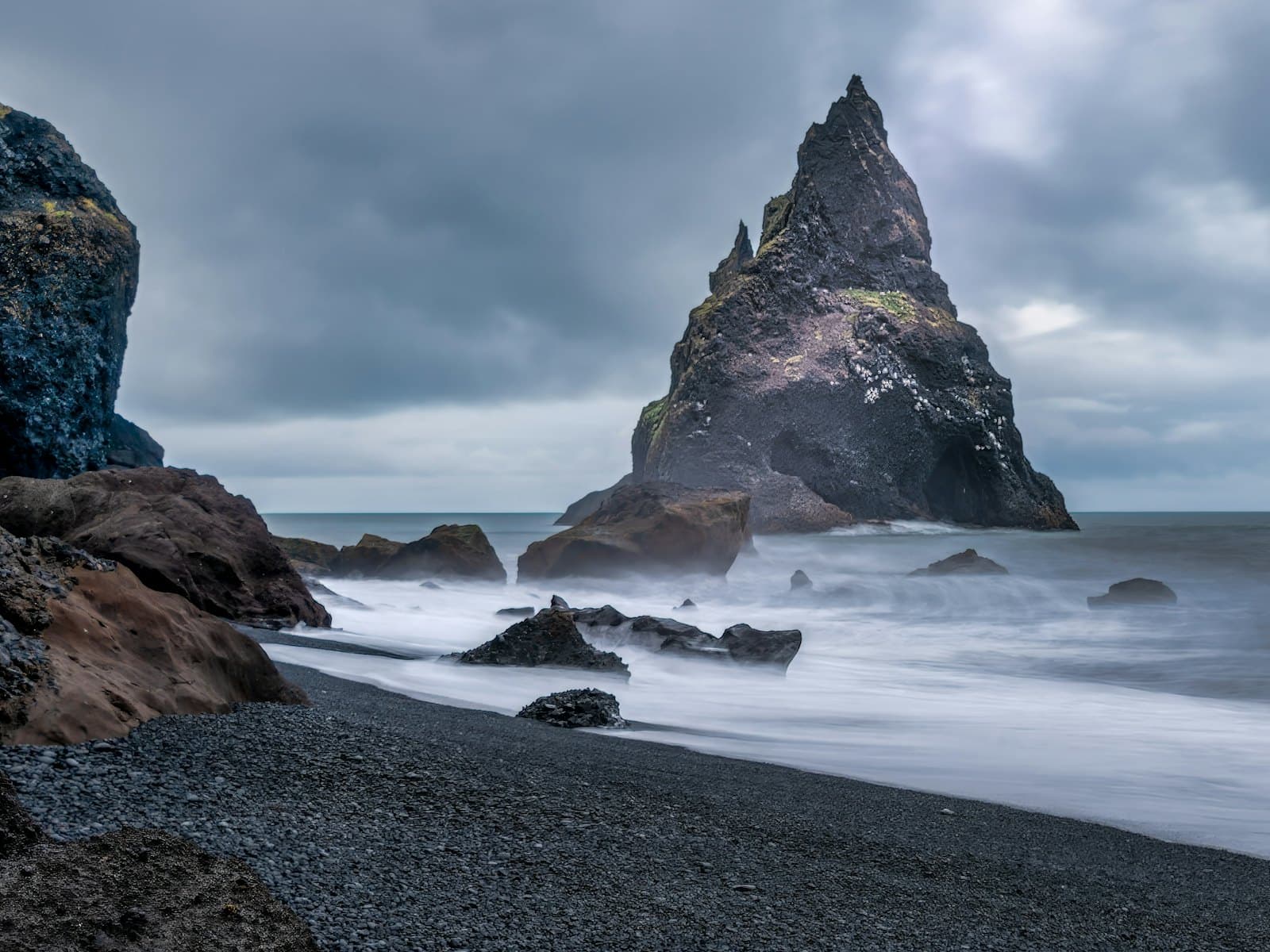 Waves breaking against a dark rocky shoreline